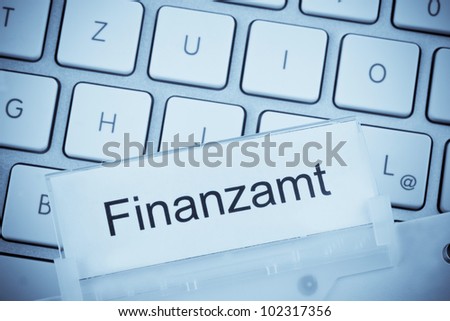 a folder for files in hanging folders in front of a computer keyboard on the topic: tax office