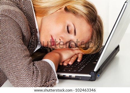 stress and fatigue in office. sleep on laptop at a desk.