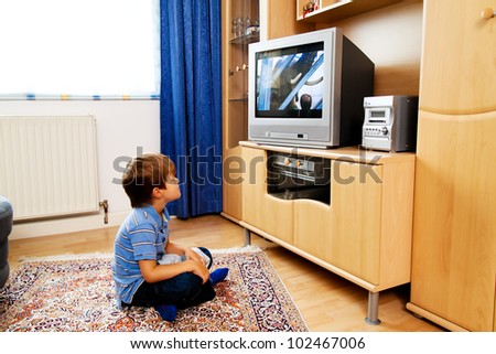 a small child watching television with tv