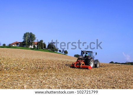 a farmer with his tractor at work in a field.