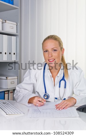 a young doctor with stethoscope in her doctor\'s office.