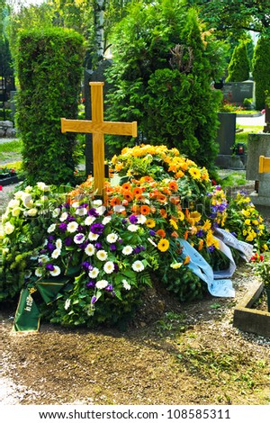 in a cemetery, a grave is fresh after a funeral.