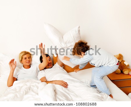 a young family is in bed in the bedroom