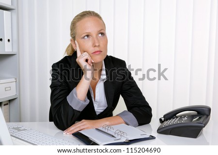 a pensive businesswoman sitting at her desk in an office