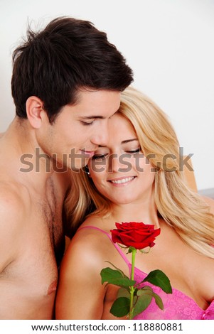 a romantic couple in bed with rose. marry the man.