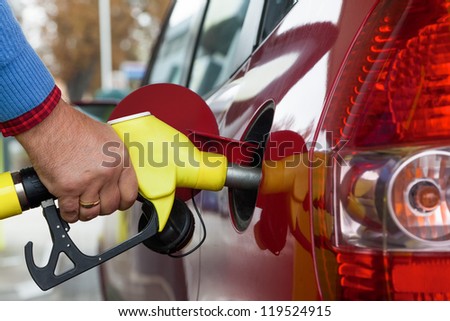 a young woman at a gas station gasoline tank. the cost of the car because of the gas prices are getting more expensive