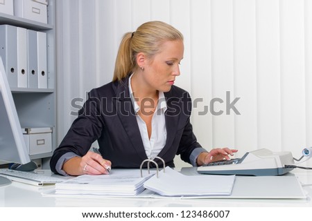 an accountant at work in the office with calculator an accountant at work in the office with calculator
