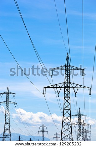 a high voltage power pylons against blue sky.