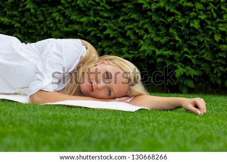 a young woman lying in the grass to rest. lunch in the park