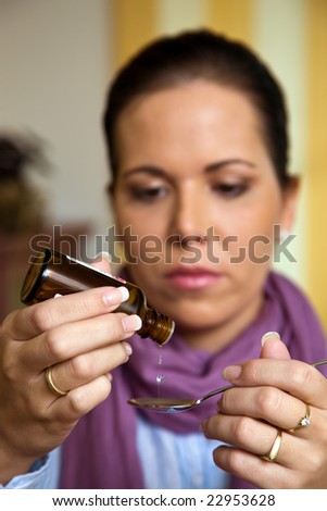 The ill woman takes a drop of medicine