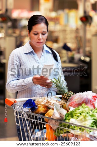 Young woman controls a bill of sale in supermarkets
