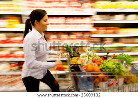 Young woman with shopping cart in the supermarket when shopping
