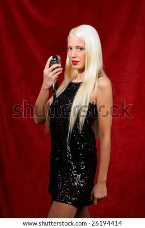Young blond girl sings in the evening gown