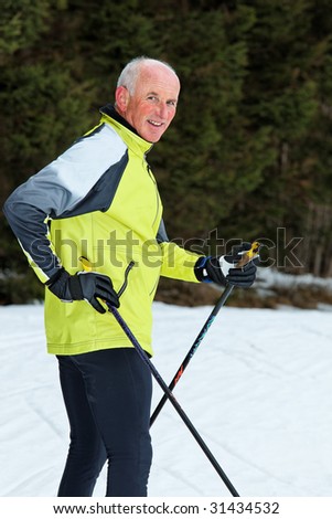 Senior in winter on snow with skis at the Cross