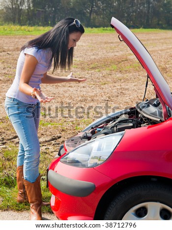 Young woman in her car breaks down. Engine failure