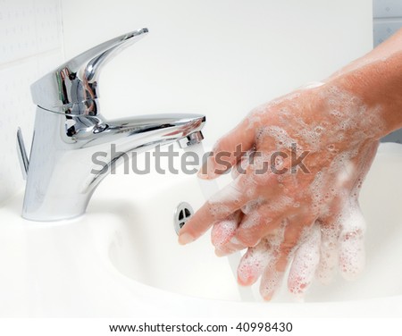 Women washes with running water and soap hands. Protection against the new flu infection.