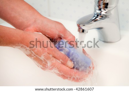 Women washes with running water and soap hands. Protection against the new flu infection.