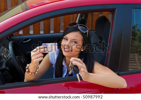 Woman with new car and driveru0026#39;s license and car keys