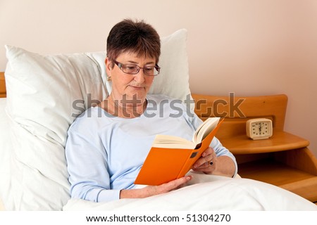 a senior citizen in the nursing home in bed reading the book