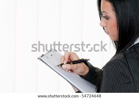 Young manager with a clipboard in Controlling takes notes