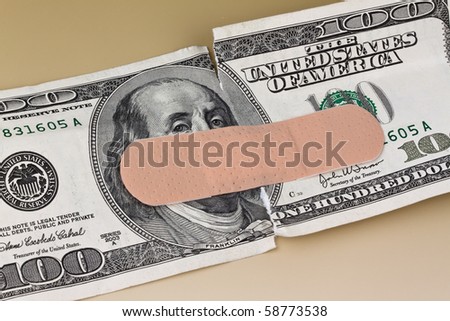 Many dollars banknotes with a band-aid