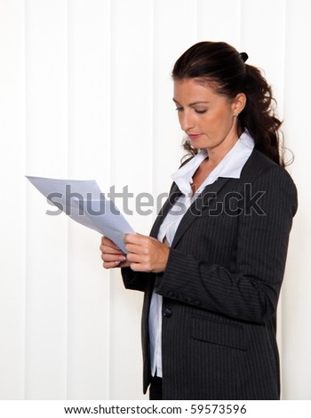 Businesswoman reading a letter in the office. News of the lawyer or tax office.
