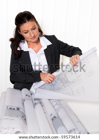 Architect with blueprint in the office. Plans of a house will be processed