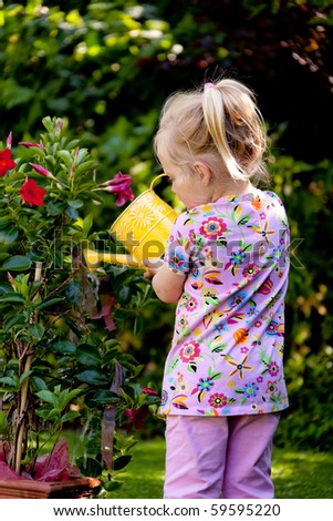Small child with a watering can with flowers pour