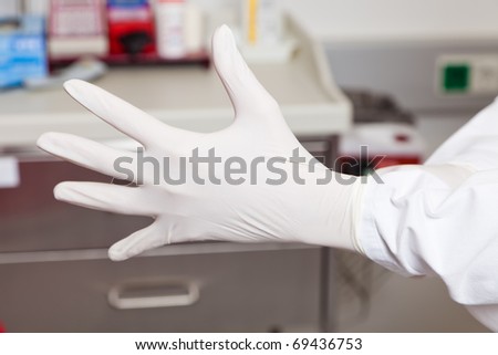 A doctor putting on latex gloves. Protection and safety in the laboratory.