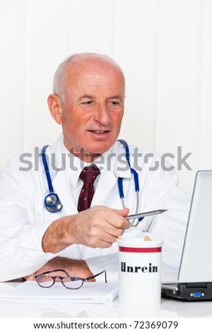 A doctor in his medical practice with stethoscope and laptop.