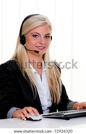 Young woman with headset at computer hotline. Friendly Clerk