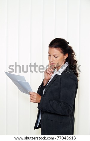 Businesswoman reading a letter in the office. Message from the attorney or tax office.
