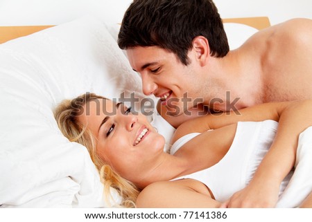 Couple has fun in bed. Laughter, joy and eroticism in the bedroom