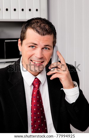 Young Businessman in office with telephone is smiling