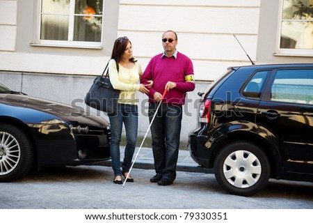A young woman helps a man on the street