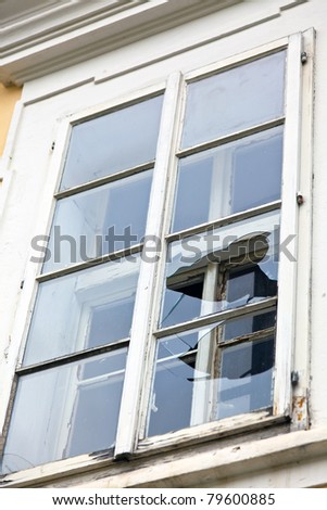 A window with a broken window pane. Broken glass.