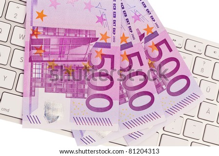500 euro banknotes are a lot of money on a pile. On a computer keyboard