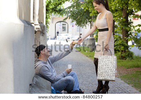 a rich young woman gives food to a beggar.