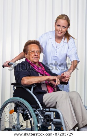 a nurse and an old woman in a wheelchair.