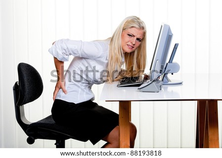young woman with pain in the back office.