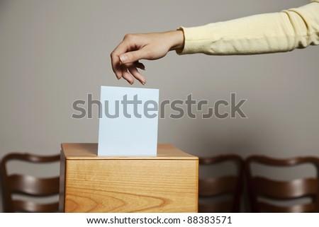 a young woman with a voter in the voting booth. voting in a democracy