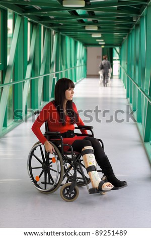 young woman with leg in plaster and wheelchair in the hospital