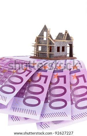 many euro banknotes and shell of a house