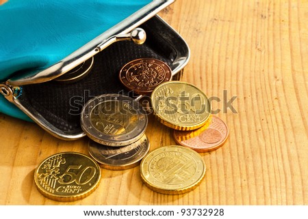 an empty wallet with a few euro coins. photo icon on debt and poverty