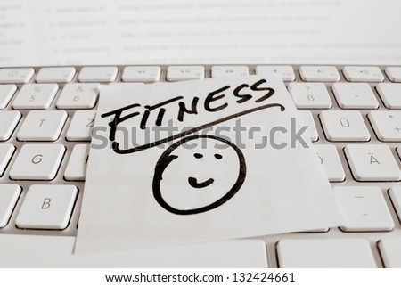 a memo is on the keyboard of a computer as a reminder: fitness