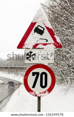 traffic signs and snow, symbol photo for winter weather, accident risk and speed limit