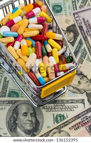 tablets, cart, dollar bills, symbolic photo for pharmaceuticals, health insurance, health care costs