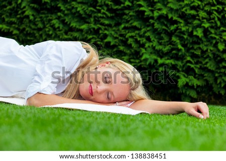 a young woman lying to rest in the meadow. lunch in the park