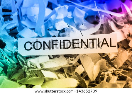 scraps of paper with the word confidential, symbolic photo for data destruction, bank secrecy and confidentiality