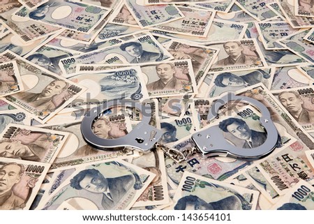 yen banknotes, currency from japan with handcuffs. crime in the economy